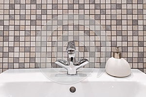 White clean bathroom sink with shiny faucet and stone soap dish.