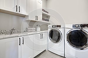 White clean modern laundry room with washer and dryer photo