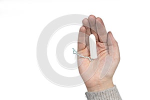 White clean tampon on woman`s hand isolated on a white background. Menstruation time. Hygiene and protection.