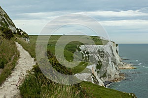 White Cliffs of Dover covered in greenery under a cloudy sky in the UK