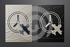 White Clock with airplane icon isolated on crumpled paper background. Designation of time before departure, check-in for