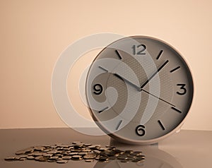 White clock and coins on left beige background