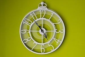 White clock on a green wall