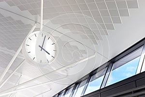 White clock hang on the floor, terminal of international airport