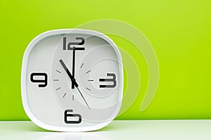 White clock on light green background