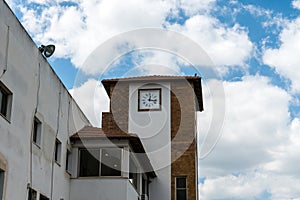 White clock tower on cloudy sky background