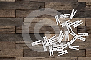 White clothespins on wooden background.