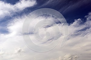 White cloud against the blue of the sky in the shape of the face