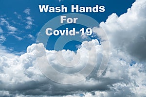 White cloud on blue sky on day time for background and a caption saying wash hands for Covid-19