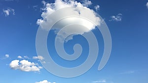 White cloud disappear in the hot sun on blue sky. Cumulus clouds form against a brilliant blue sky. Time-lapse motion clouds blue