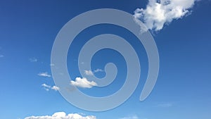 White cloud disappear in the hot sun on blue sky. Cumulus clouds form against a brilliant blue sky. Time-lapse motion clouds blue