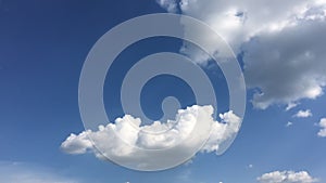 White cloud disappear in the hot sun on blue sky. Cumulus clouds form against a brilliant blue sky. Time-lapse motion clouds blue