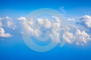 White clouds on blue sky background close up, cumulus clouds high in azure skies, beautiful aerial cloudscape view from above