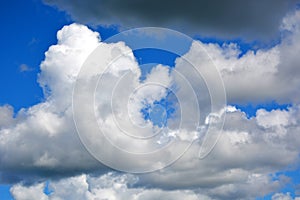 White clouds on a blue sky at noon. Beautiful atmospheric phenomenon. Natural horizontal background