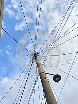 white clouds and blue sky obstructed by tangled power lines photo
