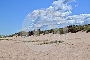 White clouds and blue sky over beach and dunes at PEI National Park