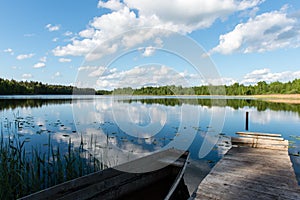 White clouds on the blue sky over blue lake with boats and board