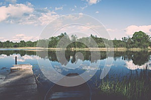 White clouds on the blue sky over blue lake with boats and board