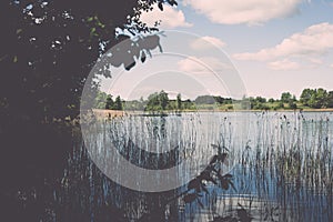 White clouds on the blue sky over blue lake - retro vintage effect