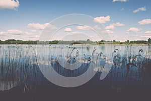 White clouds on the blue sky over blue lake - retro vintage effect