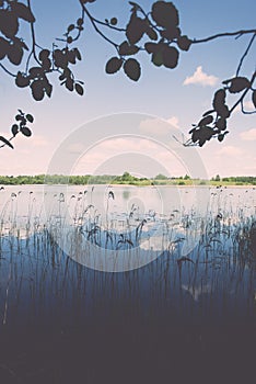 White clouds on the blue sky over blue lake - retro vintage effect