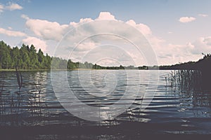 White clouds on the blue sky over blue lake - retro vintage effect