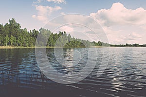 White clouds on the blue sky over blue lake - retro vintage effect