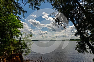 White clouds in the blue sky over the river.