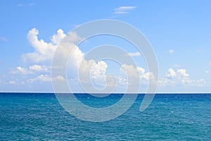 White clouds on a blue sky and sea. Sunny day on the Aegean. Calmness and harmony. The horizon between the sky and the sea. Greece