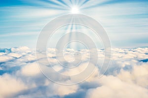 White clouds on blue sky with sun rays