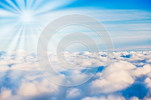 White clouds on blue sky with sun rays