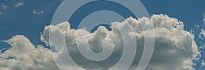 White clouds in the blue sky on a sunny day, panorama. Web banner