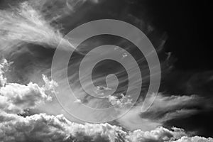 White clouds on a dark dramatic sky. Storm wind clouds. Black and white sky template