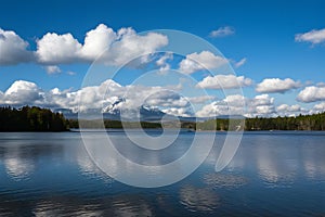 White clouds drift lazily over lake against blue sky backdrop