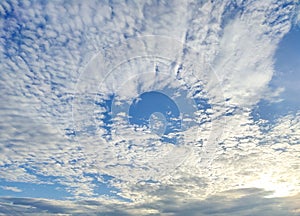 White clouds entire sky evening golden light sun shining through