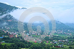 White Clouds over Himalayan Mountains and Town with Colorful Buildings in Valley - Natural Landscape with Green Environment