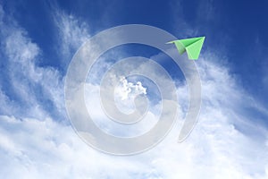 White clouds and paper airplane flying in blue sky on sunny day. Space for text