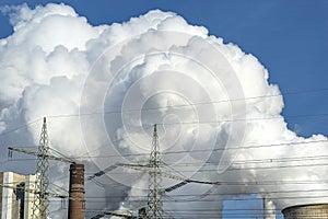 White clouds of water vapor emerging from the cooling tower of a power generating plant.