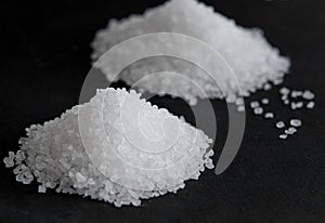White coarse sea salt on a black background
