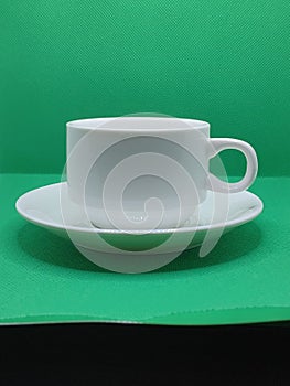 A white coffe cup closeup isolate on green background