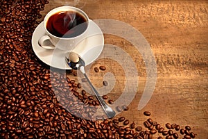 White coffee cup with beans on rustic table