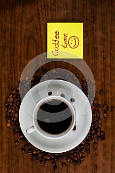 White coffee cup and coffee beans on a wooden table.Coffee time