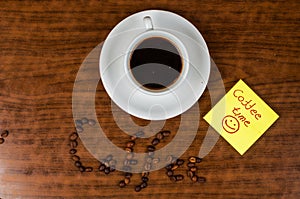 White coffee cup and coffee beans on a wooden table.Coffee time