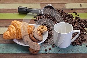 White coffee cup with cookies and beans