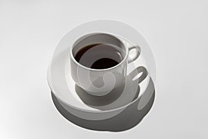 White coffee cup with espresso. hard shadows on gray background