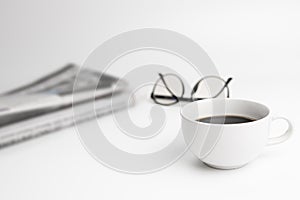 White coffee cup,glasses,News paper on the white table