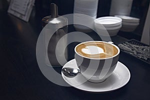 White coffee cup with heart shape latte or cappucino in coffee bar