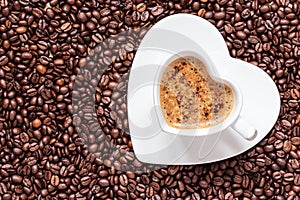 White coffee cup heart shaped with cappucino