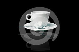 white coffee cup and saucer with spoon over black