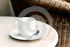 White coffee cup and saucer on a table in a street cafe. Blur, s